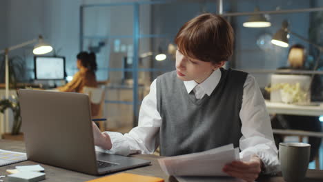 Young-Businesswoman-Working-with-Papers-Late-in-Office